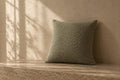 Fennel Bouclé Cushion in soft daylight against warm plaster