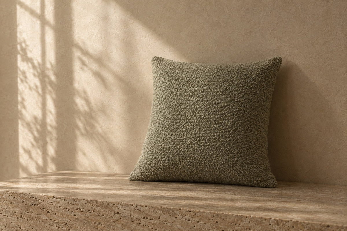 Fennel Bouclé Cushion in soft daylight against warm plaster